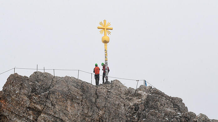 Das Gipfelkreuz des Zugspitzgipfels bei Wolken.