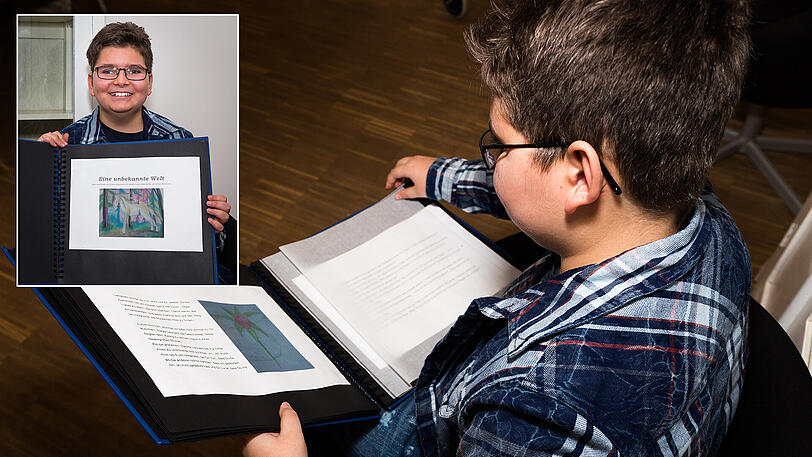 Stolz zeigt Simon das Buch, das er geschrieben hat.