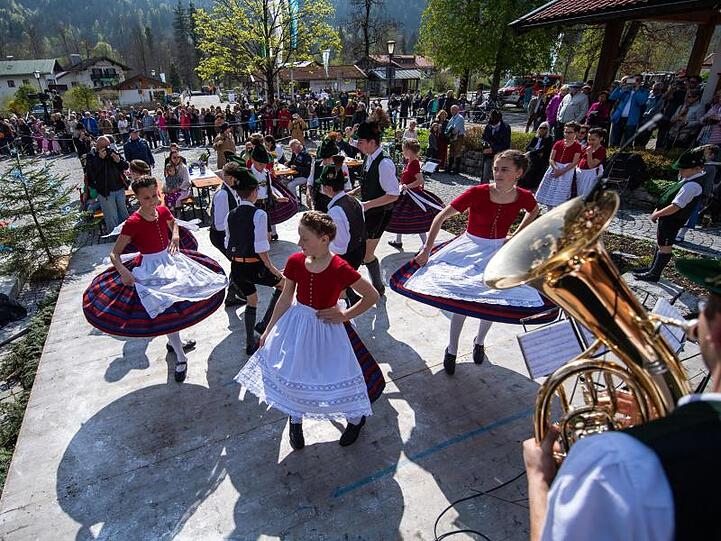 Jungen und Mädchen vom Gebirgstrachten-Erhaltungsverein "D'Leonhardstoana" tanzen in Tracht beim Maibaumfest. Foto: Lino Mirgeler