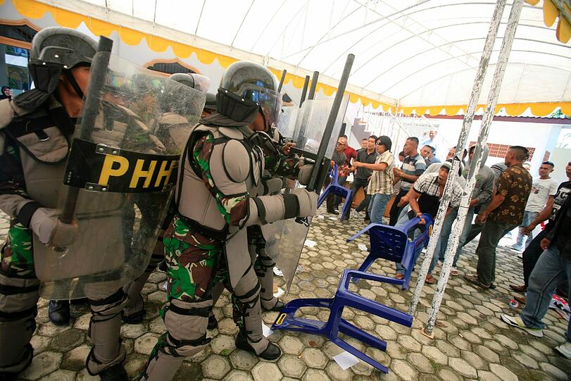 Eine Militäreinheit stellt sich in einem Wahllokal in Indonesien einem wütenden Mob aus Protestanten entgegen - zumindest in einer Übung. Die Regierung will bei den Wahlen am 9. April und am 9. Juli 2014 auf alles vorbereitet sein.