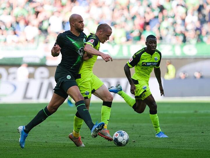 Paderborns Sven Michel (r) behauptet den Ball vor Wolfsburgs John Anthony Brooks (l).