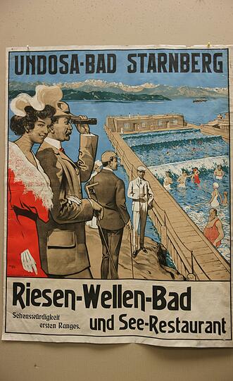 1906: Auf geht&rsquo;s, Münchner, an den See! Das Undosa-Bad in Starnberg sei nicht nur ein Riesen-Wellen-Bad mit See-Restaurant, sondern auch noch "eine Sehenswürdigkeit ersten Ranges", erklärt dieses Plakat den Sommerfrischlern. Bevor man sich in die Badeanzüge begab (übrigens auch einige Männer, wie man bei dem bärtigen Herrn in Rotweißgestreift rechts unten im Bild sehen kann), reiste die feine Gesellschaft freilich mit Hut und Handschuhen an. Ein Wellenbad kostete 1908 60 Pfennig. Die riesige Wellenmaschine, die man im Jahr zuvor ins Wasser gebaut hatte, war allerdings so reparaturanfällig, dass 1921 schon wieder Schluss war mit dem Wellenspaß.