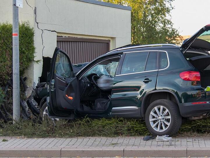 Ein beschädigter SUV steht nach einem Unfall vor einer Garage. Ein 79 Jahre alter Autofahrer hat eine Fußgängerin tödlich verletzt. Auch die 76-jährige Beifahrerin sei bei dem Unfall gestorben.