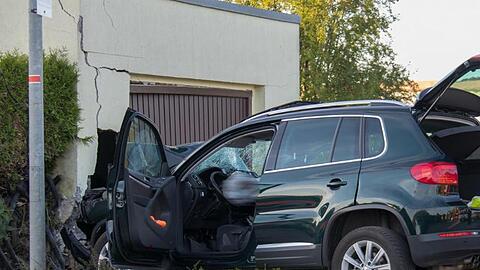 Ein beschädigter SUV steht nach einem Unfall vor einer Garage. Ein 79 Jahre alter Autofahrer hat eine Fußgängerin tödlich verletzt. Auch die 76-jährige Beifahrerin sei bei dem Unfall gestorben.