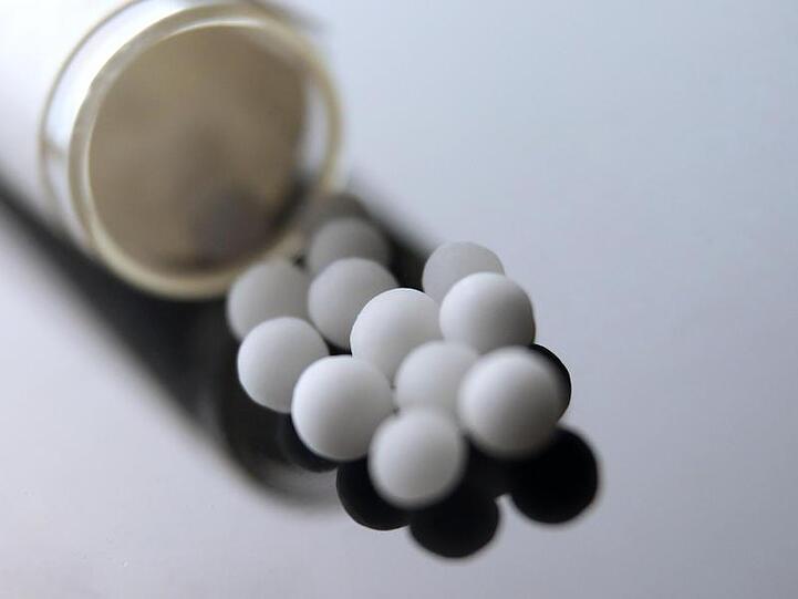 Aus einem Röhrchen wurden weiße homöopathische Globuli geschüttet. Foto: Karl-Josef Hildenbrand/Archiv