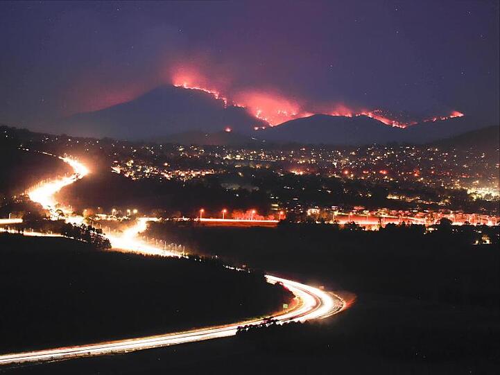 Die Buschfeuer im Orroral Valley südlich von Canberra leuchten in der Dunkelheit in den Hügeln.