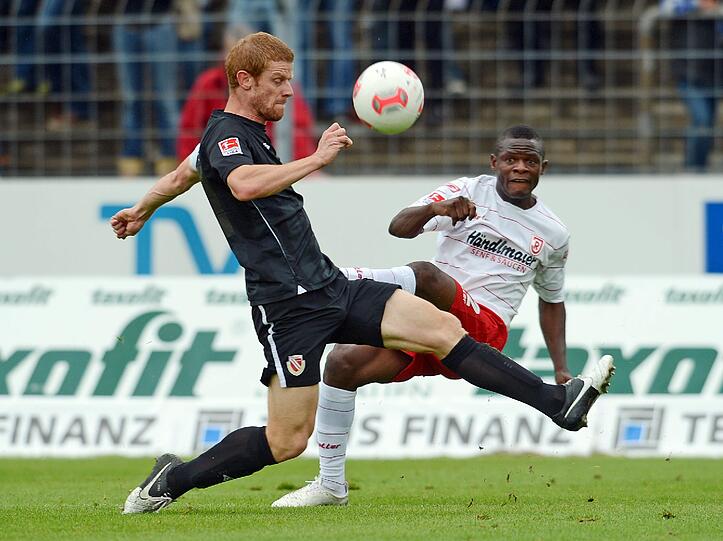 Der Cottbuser Uwe Möhrle (l) kämpft mit Regensburgs Francky Sembolo um den Ball.