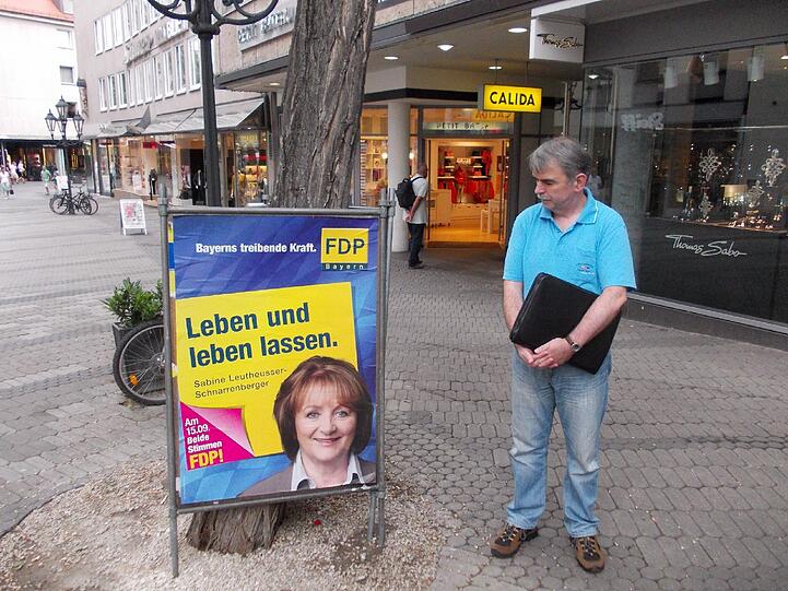 "Leben und leben lassen": Gustl Mollath beim Stadtbummel in Nürnberg vor einem Plakat von Bayerns FDP-Chefin Sabine Leutheusser-Schnarrenberger.