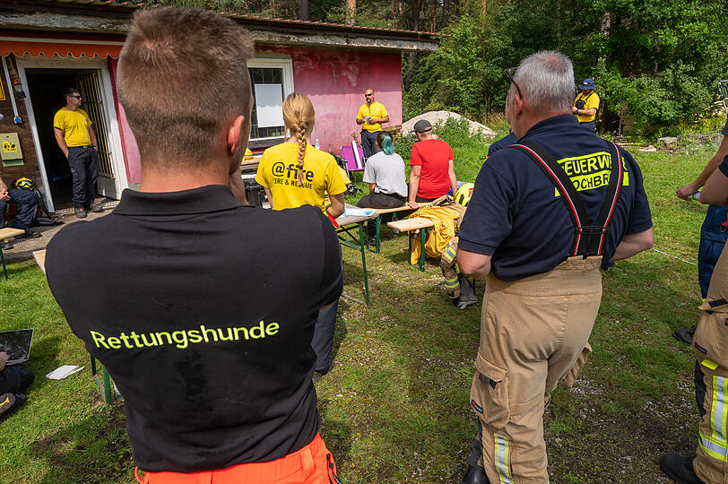 Irakli West (hinten M) von "@fire" gibt während einer Übung von verschiedenen Katastrophenschutzorganisationen auf einem ausgebauten Trümmergelände nördlich der bayerischen Landeshauptstadt Erläuterungen.