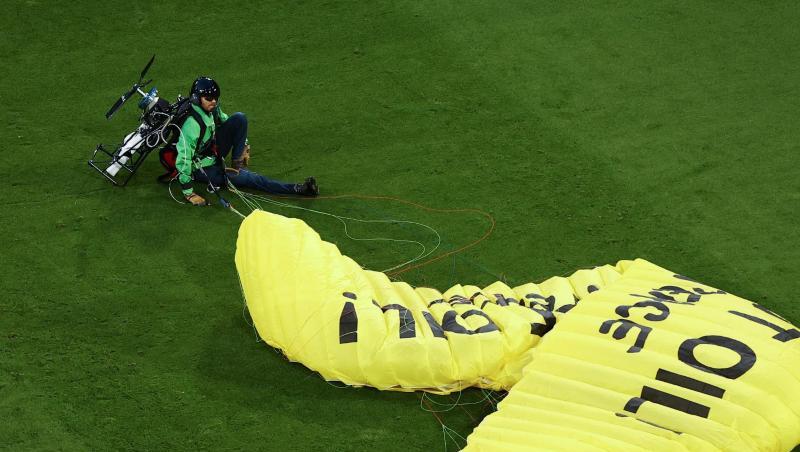 Ein Greenpeace-Aktivist wird auf dem Spielfeld gelandet.