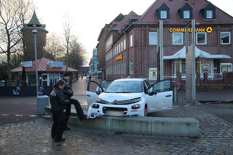 Polizeibeamte nehmen in Cuxhaven das beschädigte Auto in Augenschein. Foto: Jens Potschka/Cuxhavener Nachrichten
