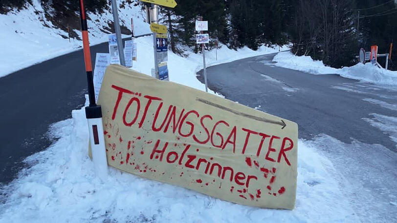 Tierschützer machen mit Schildern auf das Wildgatter aufmerksam.