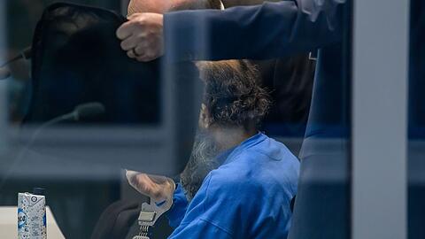 Der Angeklagte sitzt in einer Glaskabine im Verhandlungssaal.