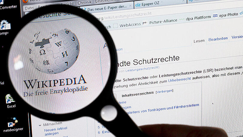 Unter einer Lupe ist das Logo Wikipedia auf einem Computerbildschirm zu sehen. Unter einer Lupe ist das Logo Wikipedia auf einem Computerbildschirm zu sehen.