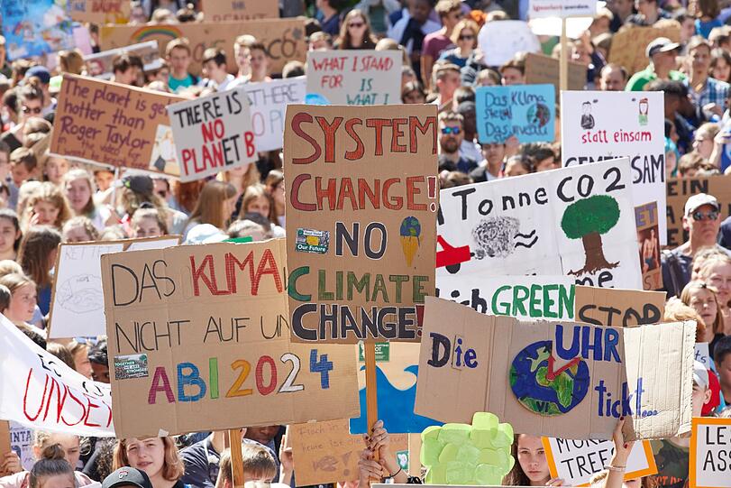 "System change! No climate change!": Teilnehmer an der Klima-Demonstration "Fridays for Future" halten Transparente hoch (Symbolbild).
