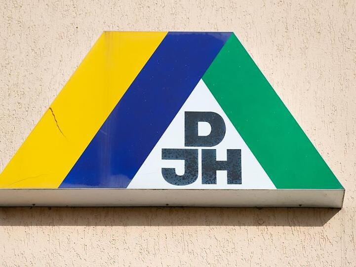 Blick auf das DJH-Logo an der Fassade einer Jugendherberge. Foto: Friso Gentsch/dpa/Archiv