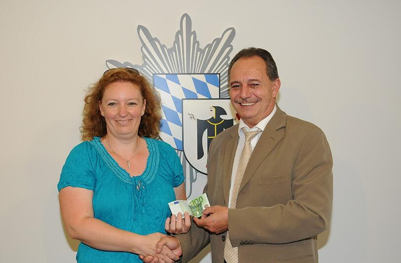 Kommissariatsleiter Thomas Lüftner überreicht Manuela K. zum Dank für ihre Hilfe 100 Euro.