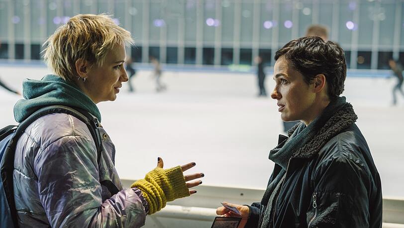 "Das Licht, das die Toten sehen": Bessie Eyckhoff (Verena Altenberger) befragt in der Eishalle Stefanie Reither (Zoë Valks) und zeigt ihr das Foto von Laura.