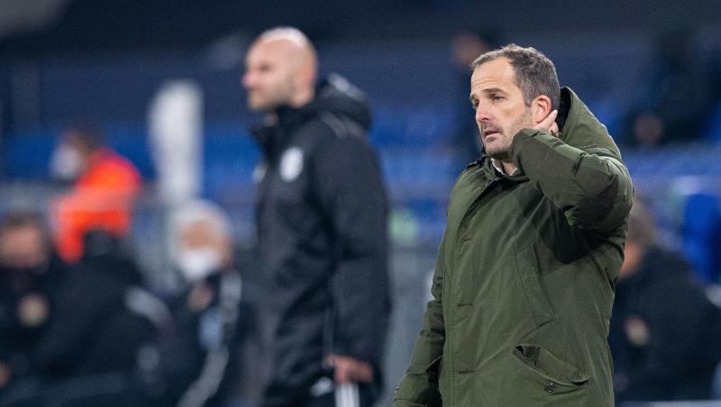 Schalkes Trainer Manuel Baum steht an der Seitenlinie und fasst sich an den Kopf.