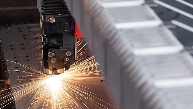 Eine Metallplatte wird in einer Produktion bearbeitet.