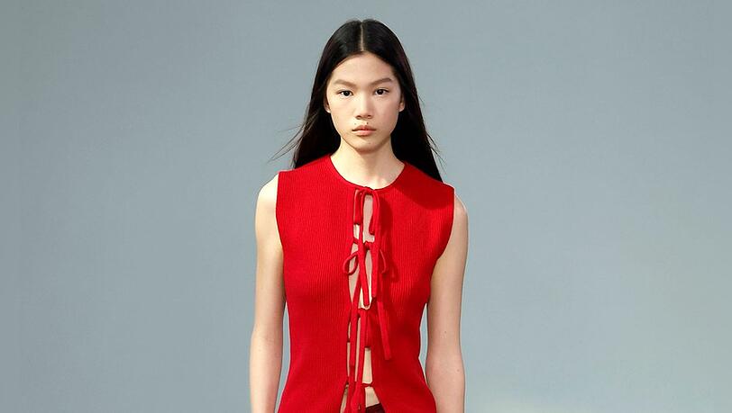 Ein Fashion-Week-Look mit einer roten Tie-Front-Bluse von JW Anderson. Ein Fashion-Week-Look mit einer roten Tie-Front-Bluse von JW Anderson.