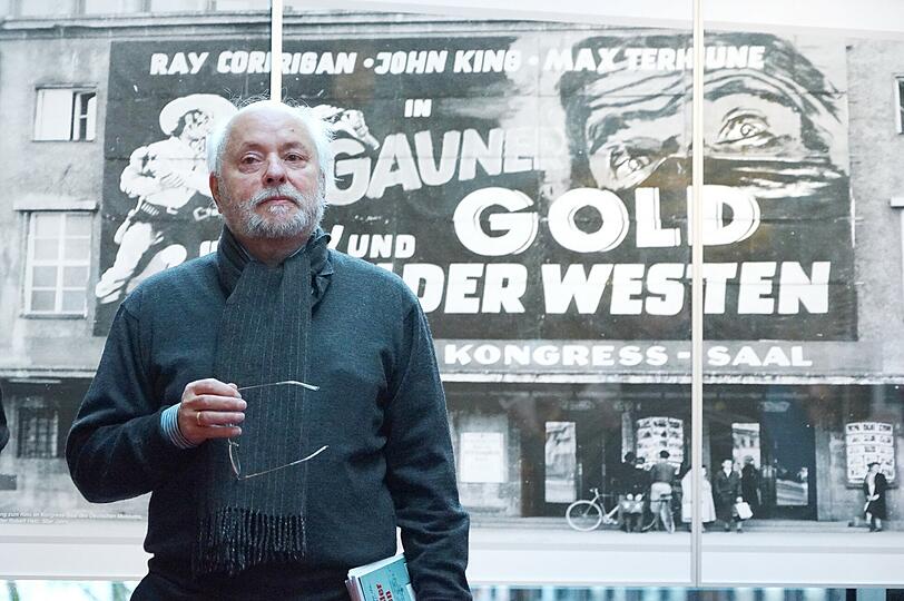 Der Ausstellungsmacher: Hermann Wilhelm vor dem Bild eines Western-Filmplakat.