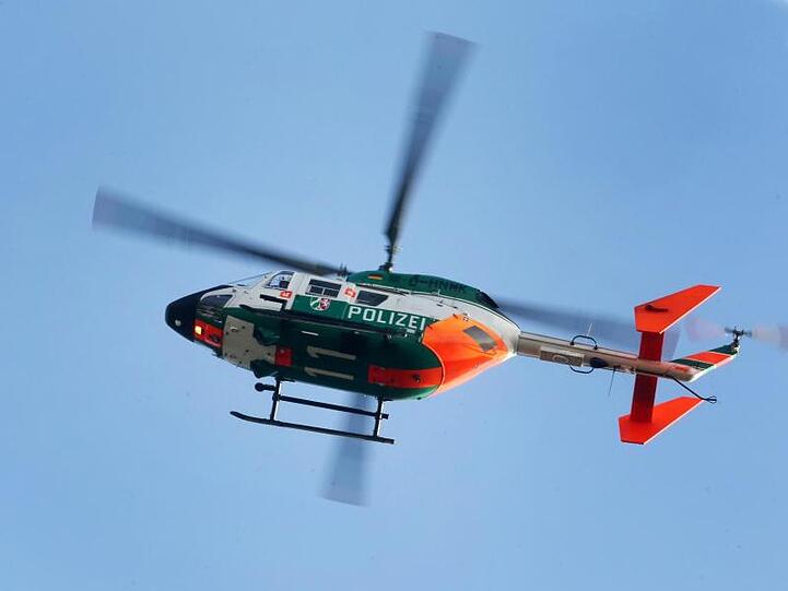Ein Polizeihubschrauber kreist durch die Luft. Foto: Roland Weihrauch/dpa/Archivbild