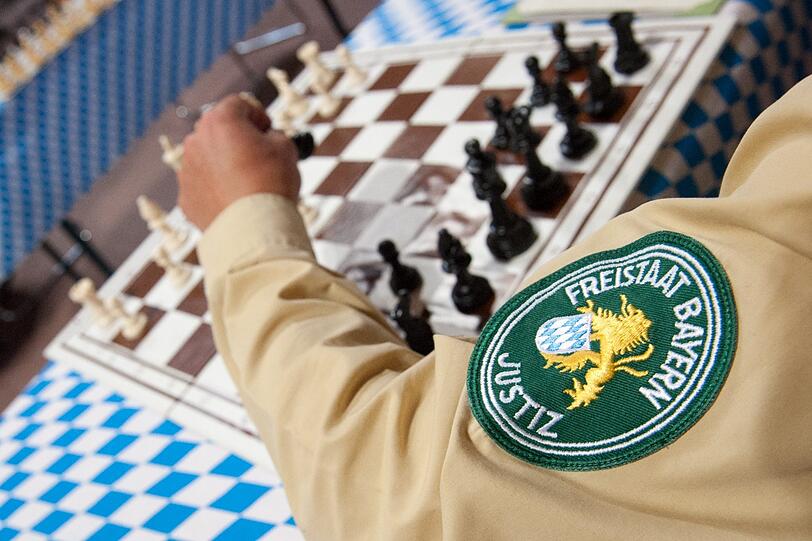 Auch ein Justizvollzugsbeamter nimmt am Simultan-Schachspiel teil.