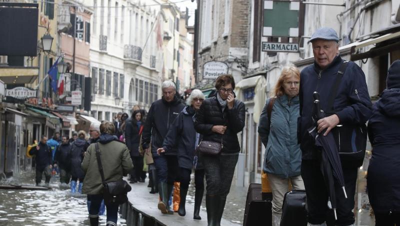Touristen ziehen ihr Gepäck über provisorische Gehsteige. Touristen ziehen ihr Gepäck über provisorische Gehsteige.