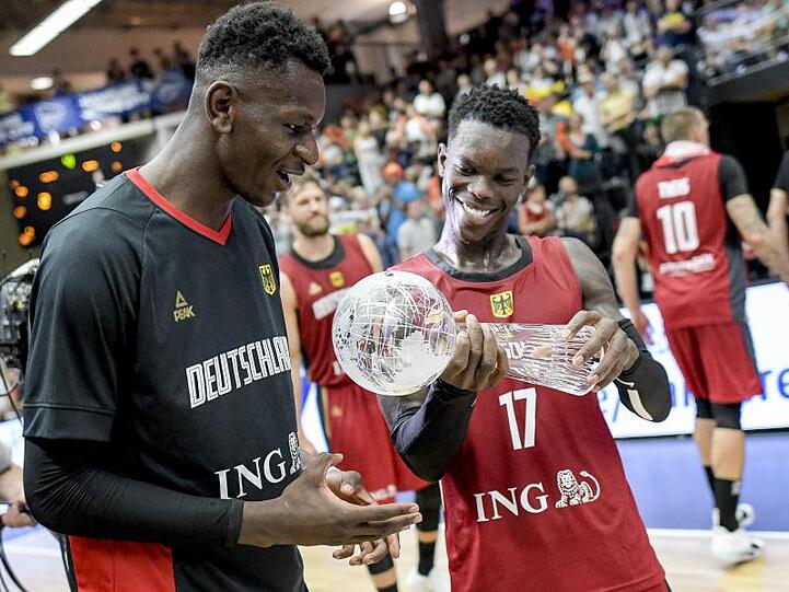 Dennis Schröder (r) und Isaac Bonga halten den Pokal in den Händen.