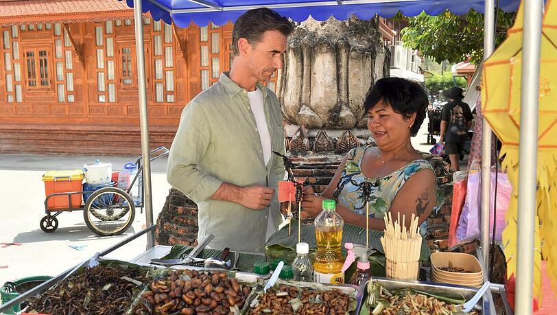"Das Traumschiff: Bangkok": Auf dem Markt lernt Max Parger (Florian Silbereisen) nicht nur eine deutschsprachige Street-Food-K&ouml;chin (Narumol) kennen, sondern auch ganz besondere Spezialit&auml;ten.