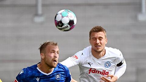 Karlsruhes Philipp Hofmann (l) im Kopfballduell mit dem Kieler Hauke Wahl.