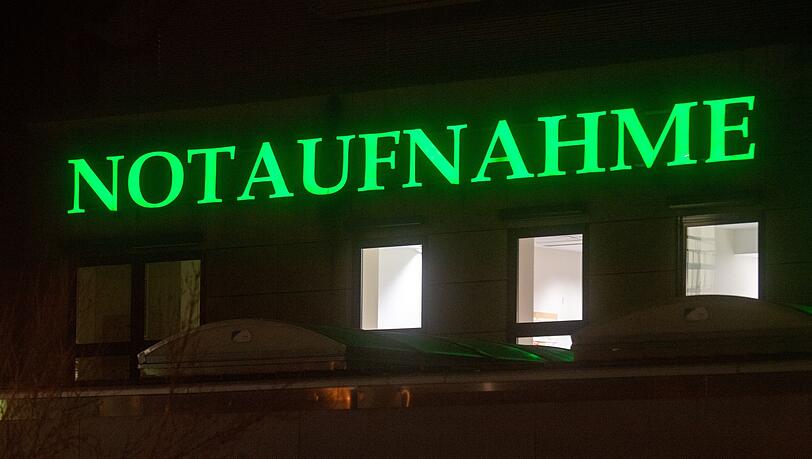 Der Schriftzug "Notaufnahme" hängt in leuchtendem Grün an einem Krankenhaus.