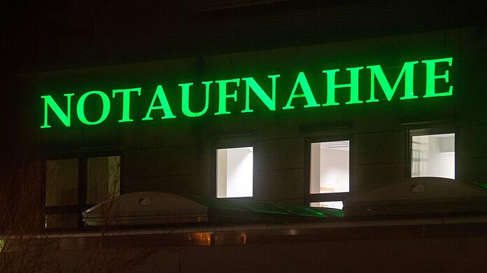 Der Schriftzug "Notaufnahme" hängt in leuchtendem Grün an einem Krankenhaus.