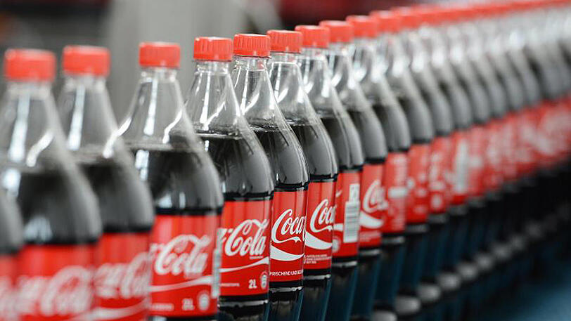 Coca-Cola-Flaschen auf einem Transportband.