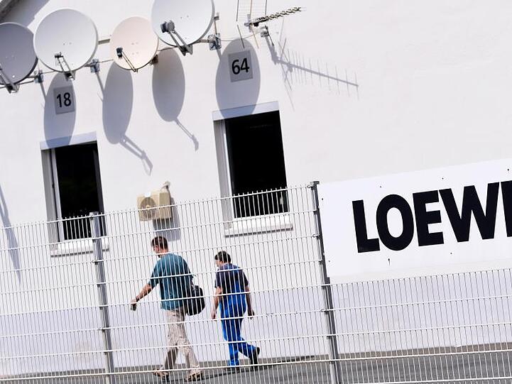 Zwei Mitarbeiter gehen über das Gelände des Elektronikherstellers Loewe AG. Foto: David-Wolfgang Ebener