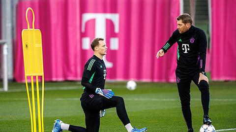 Torwarttrainer Michael Rechner (r) spricht mit Torwart Manuel Neuer vom FC Bayern München.