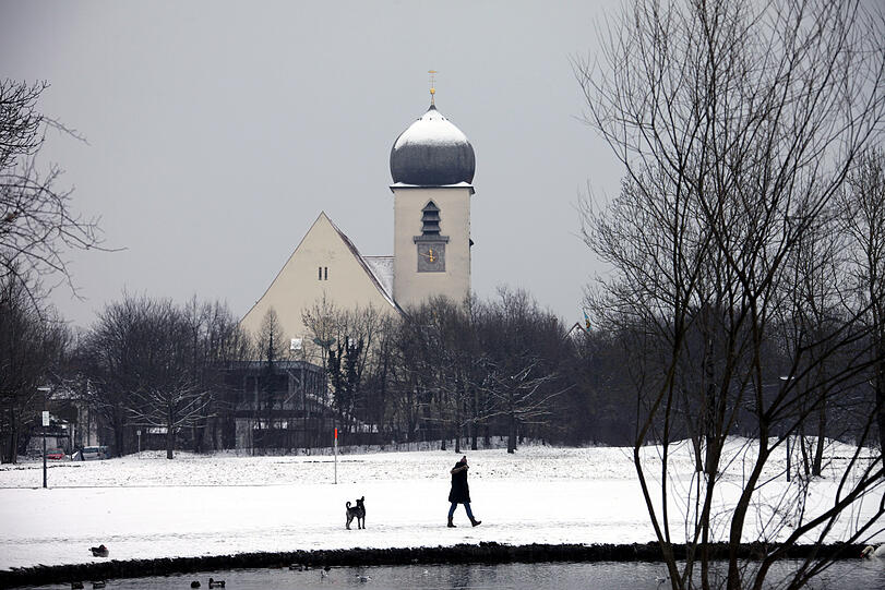 Dörfliche Idylle mitten in der Stadt: Die 1924 geweihte Obermenzinger Kirche Leiden Christi mit dem charakteristischen Zwiebelturm &ndash; im Vordergrund plätschert die Würm.