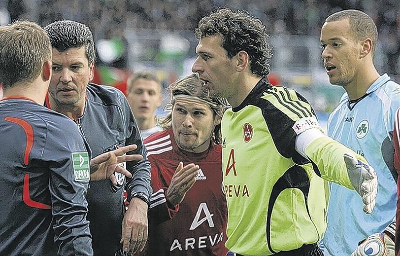 Mittendrin statt nur dabei: Raphael Schäfer (gelbes Trikot) bei Schiedsrichter Herbert Fandel.Foto: Zink
