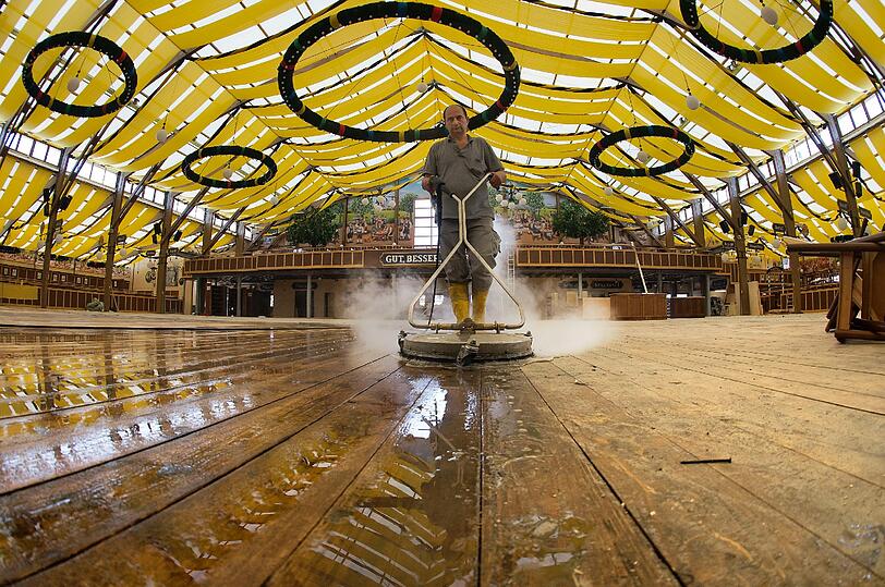 Da dampft's ordentlich! Ein Mitarbeiter eines Reinigungsdienstes putzt am Montag auf der Theresienwiese in Muenchen waehrend der Aufbauarbeiten fuer das Oktoberfest 2012 im Paulaner-Festzelt...