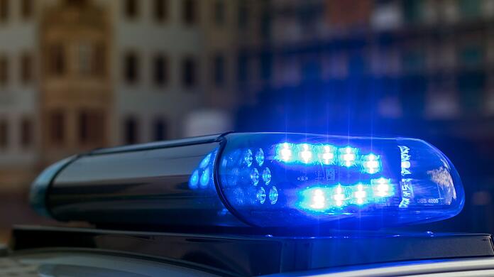 Das Blaulicht auf einem Fahrzeug der Polizei leuchtet in der Dunkelheit.