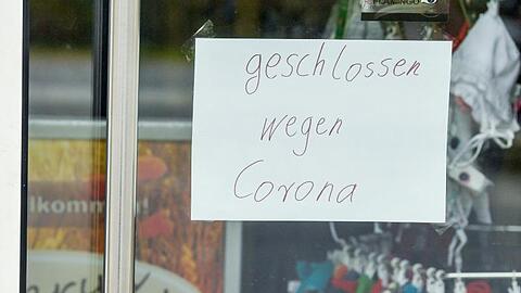 Ein Zettel mit der Aufschrift "geschlossen wegen Corona" klebt an der Tür eines Geschäfts. Ein Zettel mit der Aufschrift "geschlossen wegen Corona" klebt an der Tür eines Geschäfts.