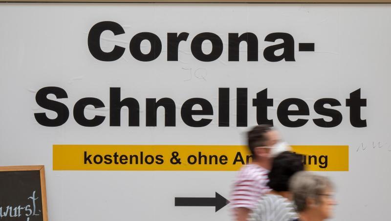 Ein Schild weist am Münchner Rathaus den Weg zu einem Testcenter.