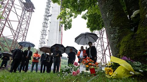 An einem Ort des Gedenkens werden Blumen niedergelegt.