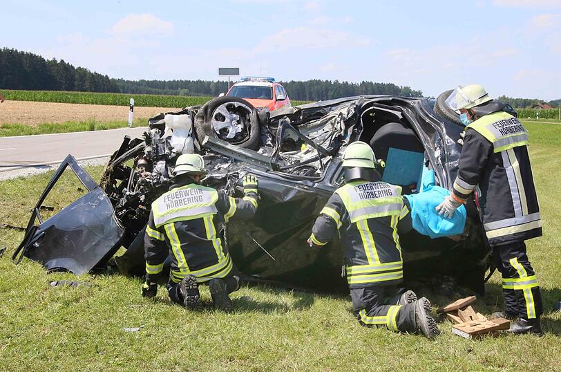 Feuerwehrleute befreien die junge Frau aus dem Wrack ihres Autos.