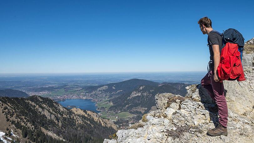 Ein Mann schaut auf dem Weg zur Brecherspitz auf den Schliersee hinab. So einsam wird es am Pfingstwochenende nicht sein in den Bergen.