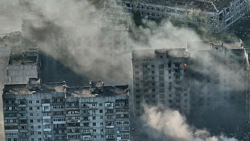 Rauch steigt aus Gebäuden in der schwer umkämpften Stadt Bachmut im Osten der Ukraine auf.