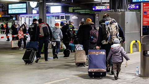 Zahlreiche Flüchtlinge aus der Ukraine gehen nach ihrer Ankunft aus der Ukraine zur Registrierung am Münchner Hauptbahnhof.