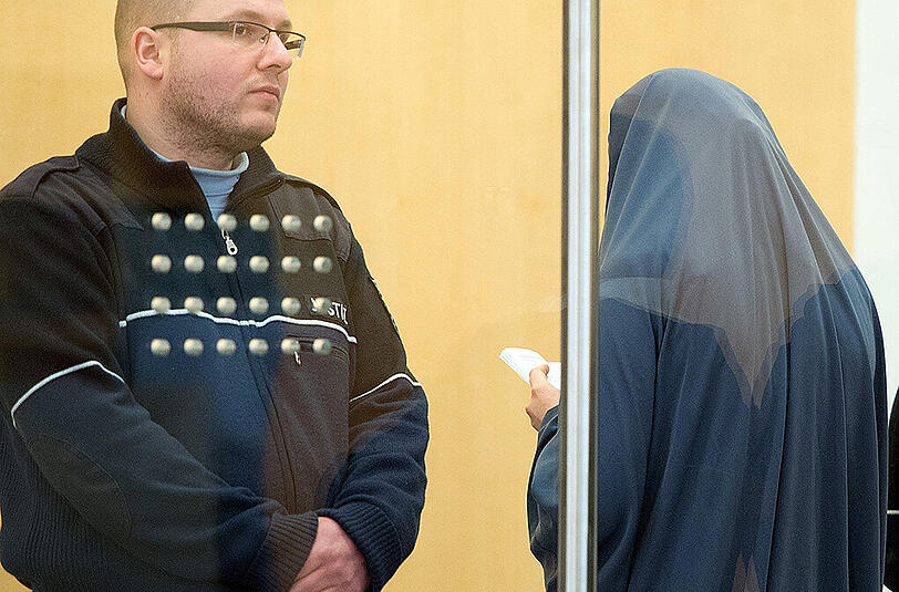 Die Angeklagte Karolina R. steht verschleiert in Düsseldorf im Gerichtssaal neben einem Justizbeamten.