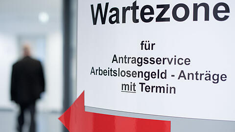Ein Mann geht in den Wartebereich für den Antragsservice Arbeitslosengeld.